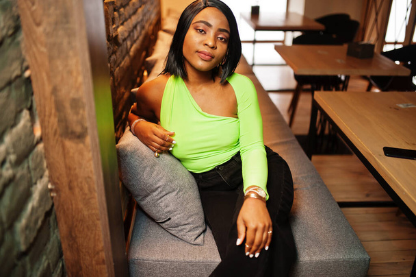 Fashionable african american woman in a light green top and black pants pose. - Foto, immagini