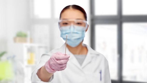 asiático médico mujer en máscara con prueba algodón hisopo - Foto, Imagen