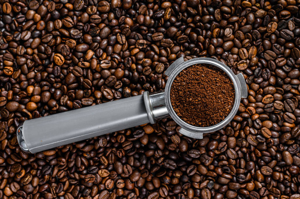 Gemalen koffie in Portafilter voor Espresso met koffiebonen. Witte achtergrond. Bovenaanzicht - Foto, afbeelding