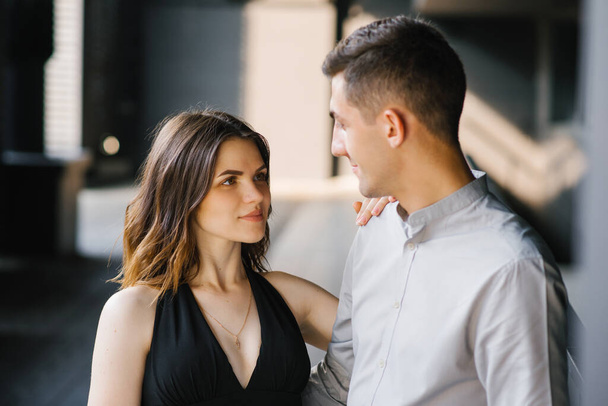 Portrait of a young beautiful couple. The girl looks into the eyes of her loved one and smiles. First date and the concept of tenderness - Photo, Image