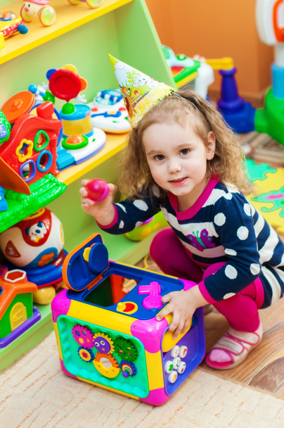 Little girl playing with toys in  playroom - Фото, изображение