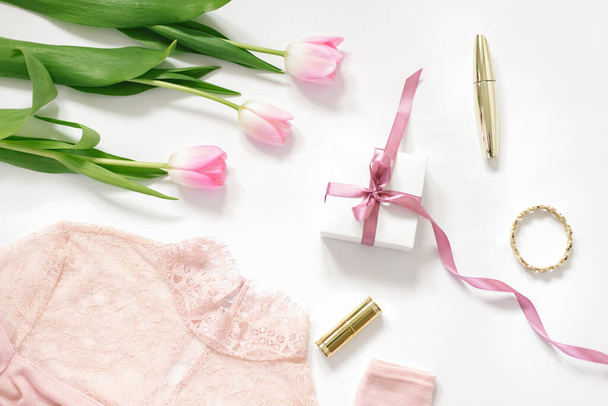Ένα μπουκέτο ροζ τουλίπες, ένα κουτί δώρου με ροζ φιόγκο, μια μπλούζα και καλλυντικά. Η έννοια της ημέρας του Αγίου Βαλεντίνου, Ημέρα της Μητέρας, Γενέθλια και άνοιξη για τον blogger - Φωτογραφία, εικόνα