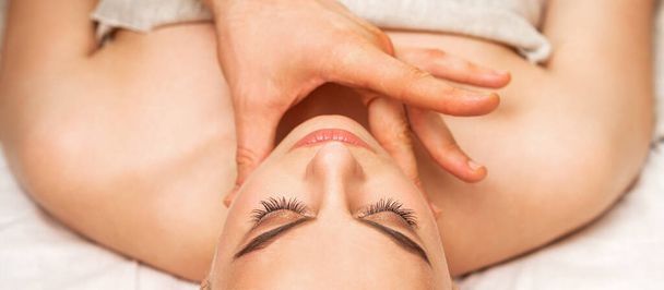 Kinn oder Nacken-Massage einer jungen Frau an der Hand eines männlichen Masseurs in einem Wellness-Salon - Foto, Bild