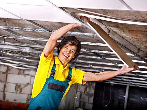 Человек устанавливает подвесный потолок
 - Фото, изображение