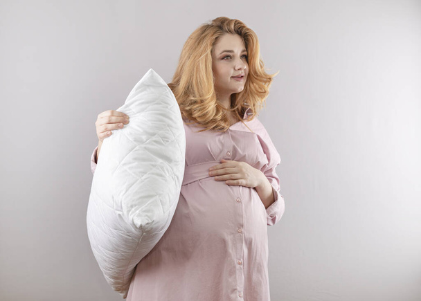 若いです妊娠中の女性とともに白い枕で彼女の手 - 写真・画像