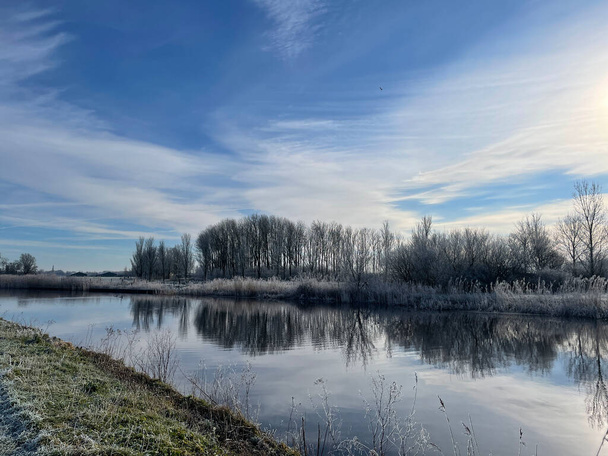 Road next to a canal around Nes during a winter day in Friesland The Netherlands - Photo, Image