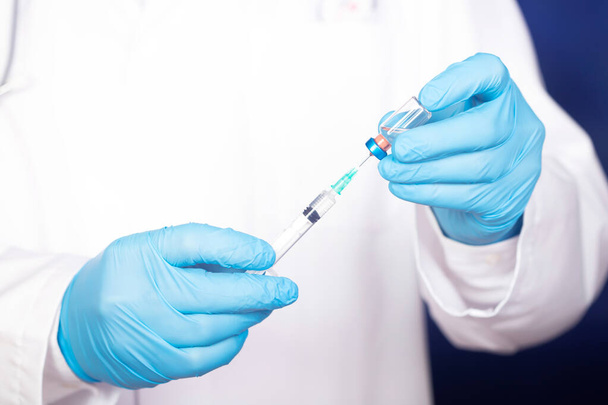 Concept of COVID-19 - Coronavirus disease - Doctor with syringe is preparing for injection. - Foto, Imagem