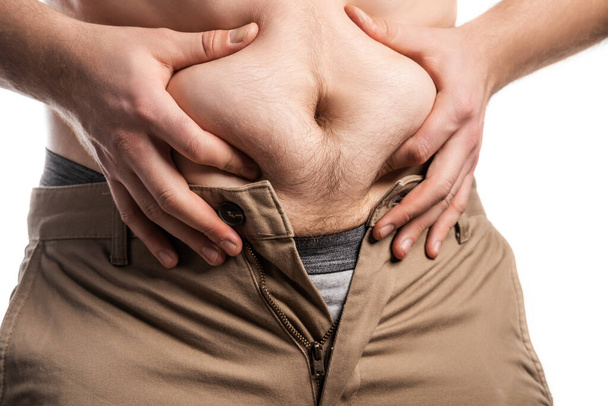 Male hands squeeze a bulging plump belly - Foto, Bild