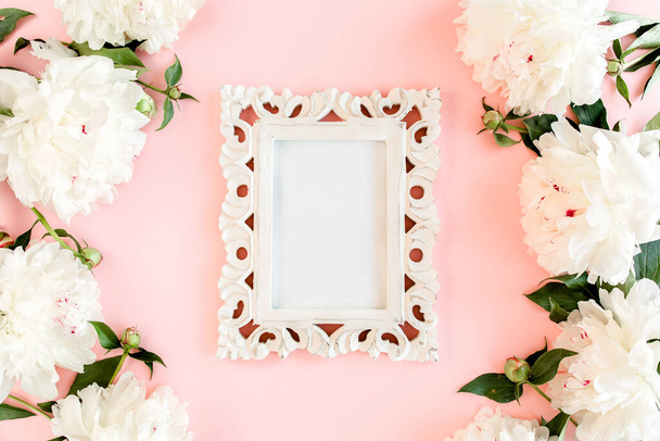 Carved, white frame decorated of white peony flowers on pink background. Peony texture. Flat lay, top view.  - 写真・画像