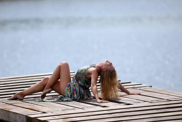 Mulher bonita Sexy relaxando no cais com vista para o mar. Conceito de férias - Foto, Imagem