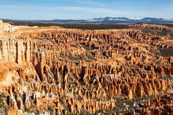  Bryce Canyon National Park, a sprawling reserve in southern Utah, is known for crimson-colored hoodoos, which are spire-shaped rock formations. The parks main road leads past the expansive Bryce Amphitheater, - Photo, Image