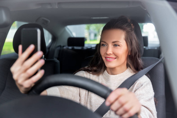 woman or driver driving car and taking selfie - Fotó, kép