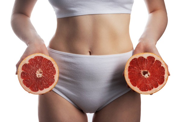 Grapefruit diet. Young woman in fitness clothing, isolated on white background - Photo, Image