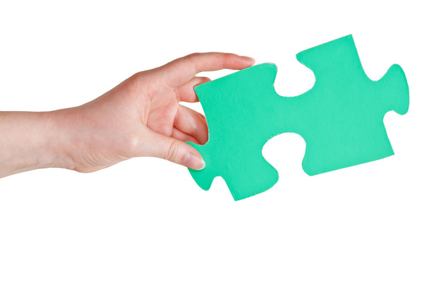 weibliche Hand hält großes grünes Papier Puzzleteil - Foto, Bild