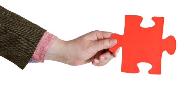 mano maschile tenendo grande pezzo di puzzle di carta rossa
 - Foto, immagini