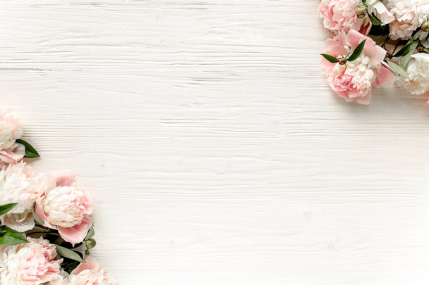 Border frame made of pink and beige peonies flower and isolated on white background. Flat lay, top view. Frame of flowers. - Foto, Bild