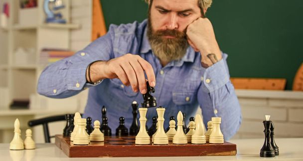more than only chess. bearded man training for chess competition. chess figures on wooden board. Focused school teacher. thinking of attack and capturing opponent chess pieces. thinking of next move - Foto, afbeelding