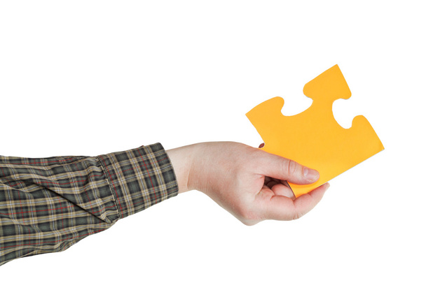 mano maschile tenendo grande pezzo di puzzle di carta gialla
 - Foto, immagini