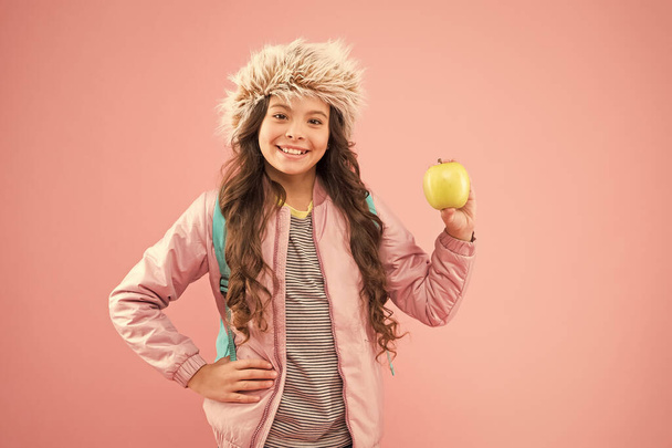 Lunch time. Winter semester. Teen with backpack. Healthy snack. Modern education. Stylish schoolgirl. Girl little smiling schoolgirl hold apple fruit. Schoolgirl happy daily life. Eating natural food - Foto, Imagem