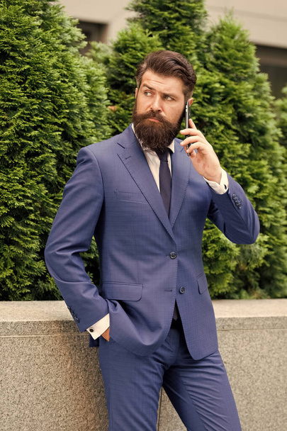 modern life concept. portrait of confidence. successful insurance agent. your future employer. handsome manager use smartphone. man in formal outfit stand outside. realtor button jacket - Foto, Bild