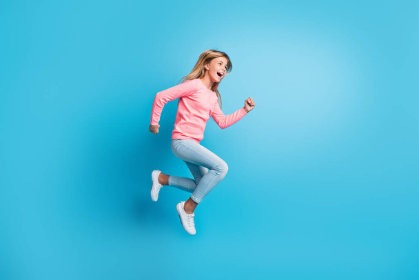 Fénykép portré lány jumping up fut elszigetelt pasztell kék színű háttér - Fotó, kép