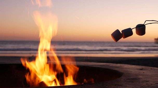 Campfire pit in California USA. Camp fire on ocean sea beach, roasting toast marshmallow on bonfire. - Photo, Image