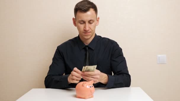 Muž počítá dolary a schovává peníze v náprsní kapse košile - Záběry, video
