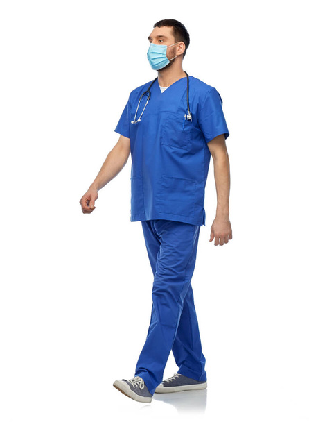 mies lääkäri sininen univormu ja naamio kävely - Valokuva, kuva