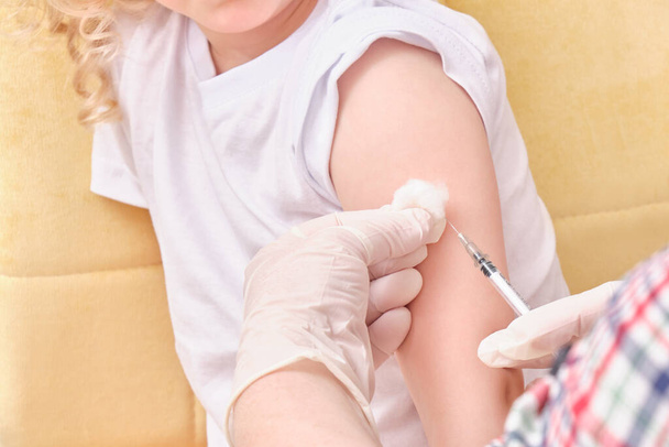 A doctor makes a vaccination to a child - Foto, afbeelding