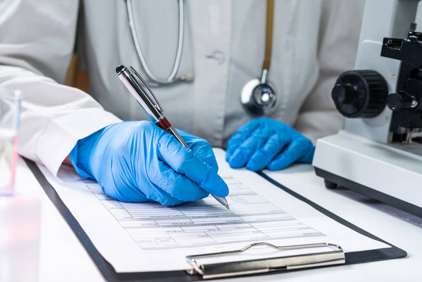 coronavirus 2019-nCoV virus,medical doctor s hand holding blood sample and making notes writing patients data on prescription - Foto, Bild