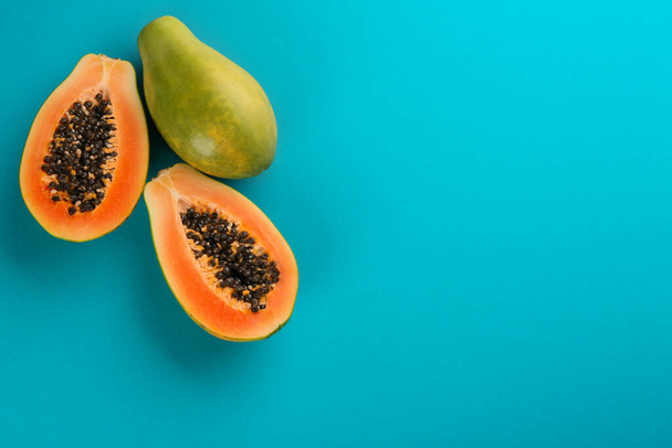 Fresh ripe papaya fruits on blue background, flat lay. Space for text - 写真・画像