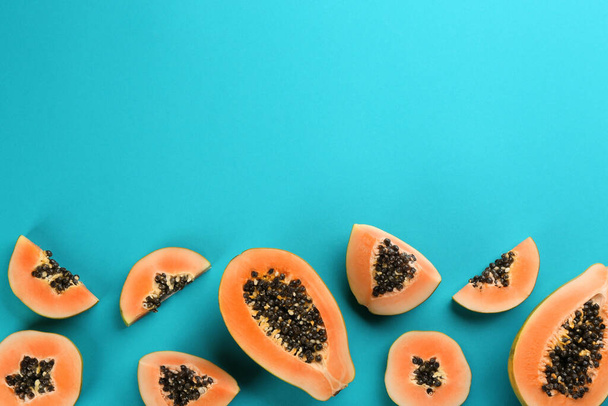 Fresh ripe papaya fruits on blue background, flat lay. Space for text - Φωτογραφία, εικόνα