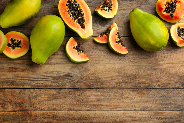 Fresh ripe papaya fruits on wooden table, flat lay. Space for text - Foto, Bild