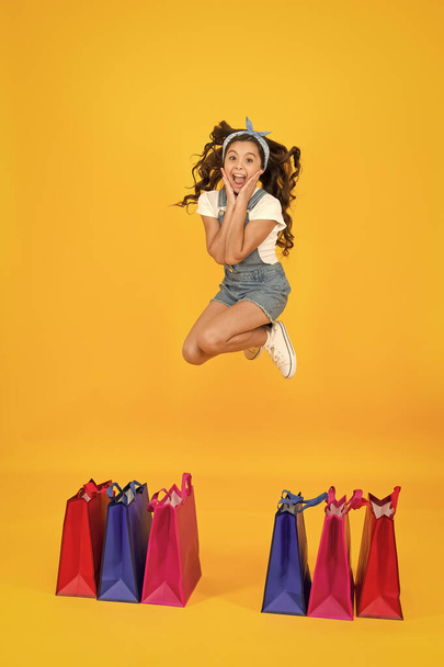 happy little beauty jump high. little shopper choose purchase. gift for any taste. sell-out concept. summer fashion shopping. savings on purchases. big deal discount. small girl has retro look - Foto, immagini