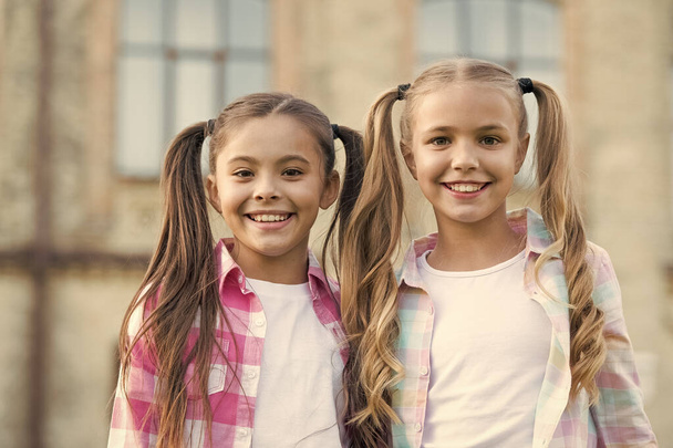 We are friends. Cheerful schoolgirls on sunny day. Girl ponytails hairstyle enjoy relax. Living happy life. Happy smiling friends. Have fun. Happy kids relaxing outdoors. Sisterhood and friendship - Foto, Imagen