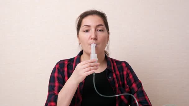 Mujer morena respira vapor usando tubo nebulizador oral - Imágenes, Vídeo