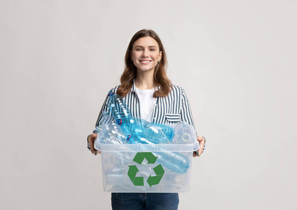 Muovin kierrätys. Positiivinen Millennial nainen tilalla säiliö pullot kierrätykseen - Valokuva, kuva
