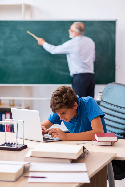 Old male teacher and schoolboy in the classroom - Photo, Image
