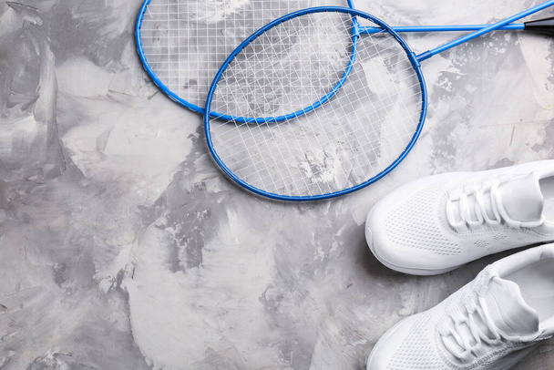 Badminton rackets and shoes on white marble table, flat lay. Space for text - Фото, изображение