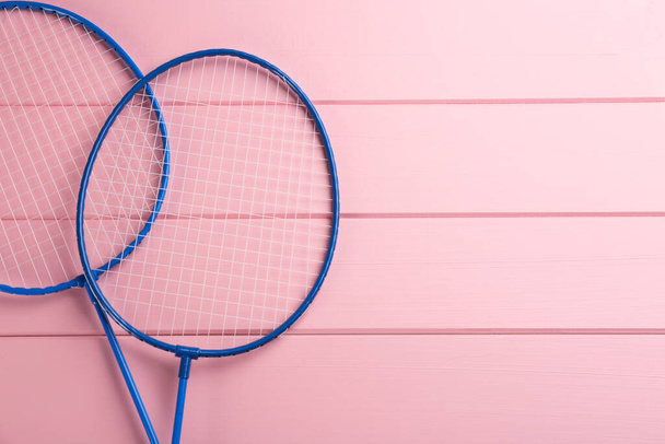 Rackets on pink wooden table, flat lay with space for text. Badminton equipment - Valokuva, kuva