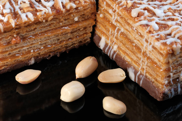 Вафельний карамельний торт з арахісом крупним планом на чорному фоні макрофотографія
 - Фото, зображення