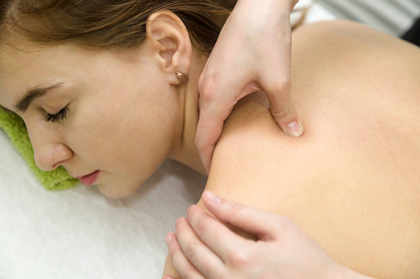 Medizinische Massage gegen Nackenschmerzen schöne Frau aus nächster Nähe. - Foto, Bild