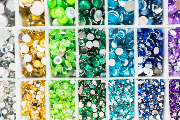 Color y tamaño variedad de diamantes de imitación en la caja de artesanía. - Foto, imagen