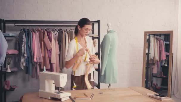 Σχεδιαστής φορώντας κασκόλ σε κούκλα στο εργαστήριο  - Πλάνα, βίντεο