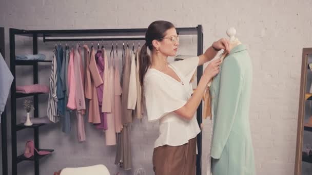 Designer meten jas op etalagepop in werkplaats  - Video