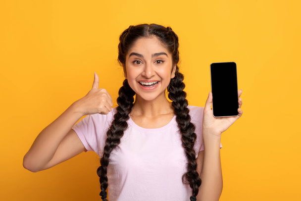 Ινδή γυναίκα δείχνει κενή οθόνη smartphone και τους αντίχειρες επάνω χειρονομία - Φωτογραφία, εικόνα