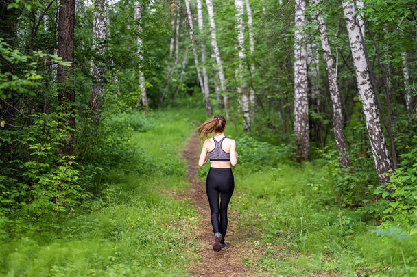 Pretty young girl runner in the forest - Foto, imagen