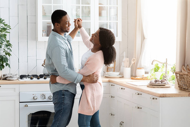 Романтическая афроамериканская пара танцует на кухне - Фото, изображение
