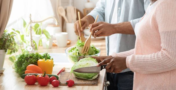 Imagen recortada de pareja afroamericana cocinando comida vegetariana saludable en la cocina - Foto, Imagen