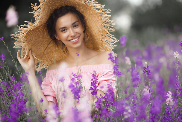 Sexy elegant woman on the meadow of flowers. Beautiful female outdoors. Freedom concept - Foto, imagen